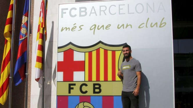 Arda Turan di depan lambang Barcelona