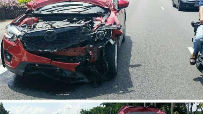 Mazda yang ringsek dihantam ban truk yang copot.
