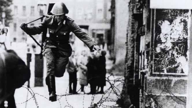 Conrad Schumann, tentara Jerman Timur meloncati pagar kawan ke Berlin Barat.
