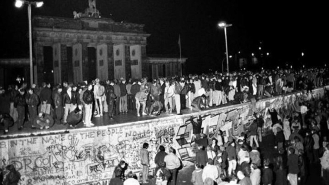 Warga Jerman Timur dan Barat merayakan runtuhnya Tembok Berlin, 9 November 1989.