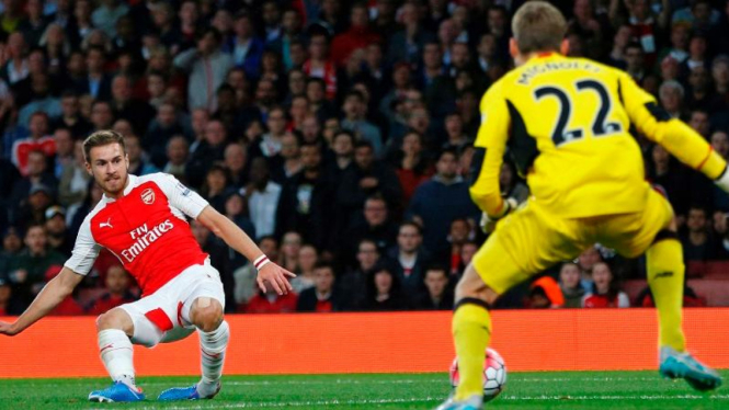 Pemain Arsenal, Aaron Ramsey menendang bola di depan gawang Liverpool