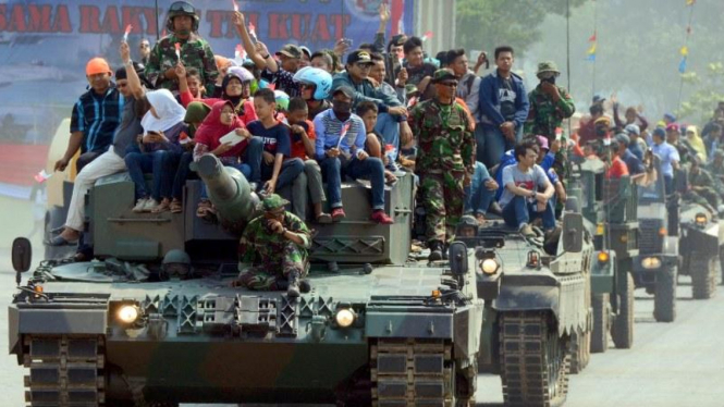 Masyarakat naik kendaraan tempur tank TNI