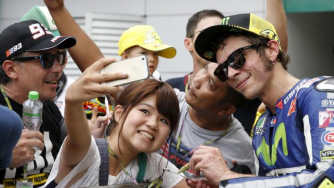 Pembalap Yamaha Valentino Rossi berfoto dengan fans di Sirkuit Sepang.