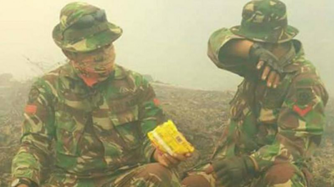Dua personel TNI saat beristirahat usai memadamkan api