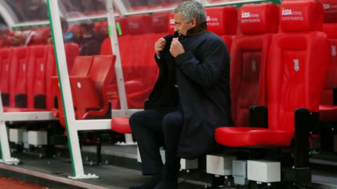 Jose Mourinho duduk di bangku cadangan.