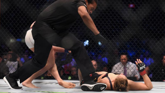 Ronda Rousey dikanvaskan Holly Holm di Melbourne, 15 November 2015.