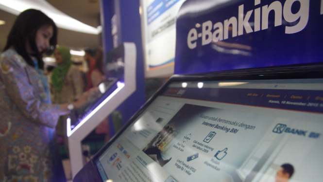 Seorang nasabah menggunakan fasilitas e-banking di Jakarta. 