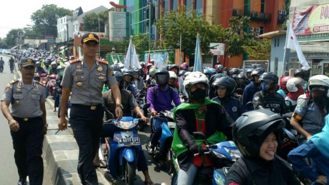 Polisi mengawal aksi mogok nasional buruh di Depok, Jawa Barat.