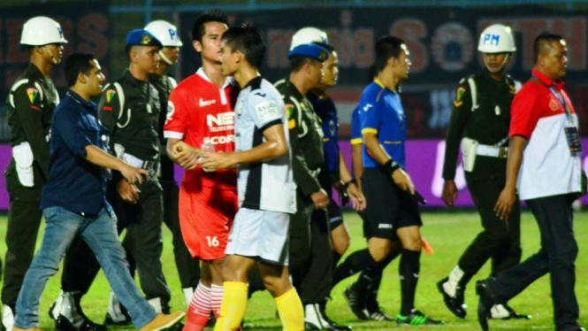 Petugas keamanan mengawal wasit di laga Persija Vs Sriwijaya FC