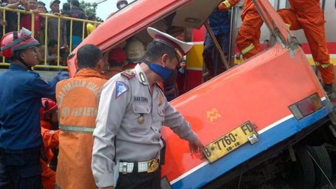 Petugas evakuasi bangkai Metro Mini yang ditabrak KRL di Angke, Jakut.