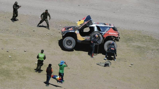 Sebastian Loeb dan rekannya sedang ganti ban di Rally Dakar