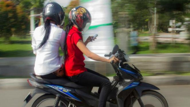 mengendarai motor sambil main handphone