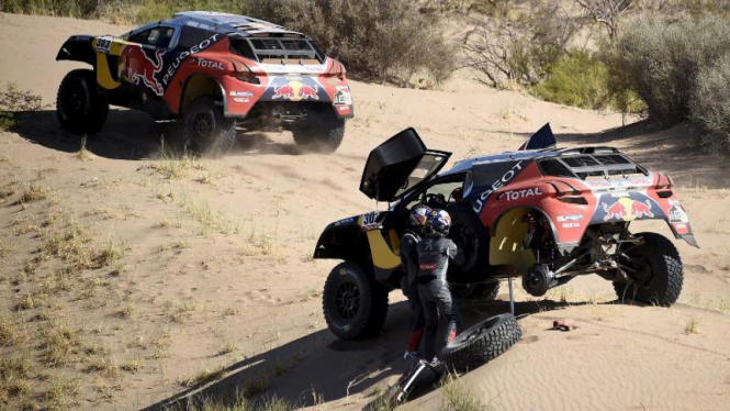 Pengendara Peugeot Peterhansel mengganti ban mobilnya di Reli Dakar 2016.