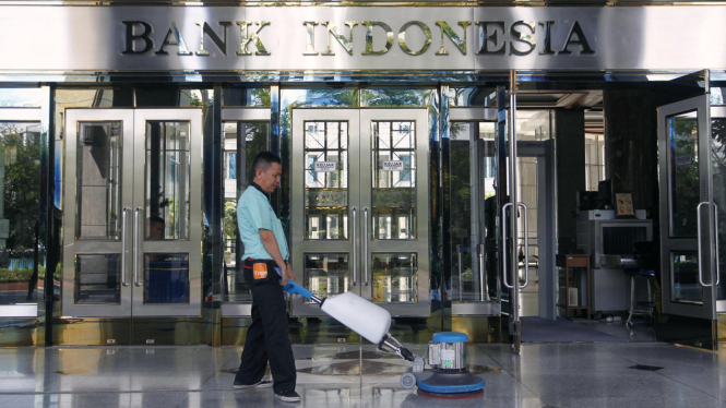 Petugas membersihkan lantai di dekat pintu masuk Bank Indonesia, Jakarta