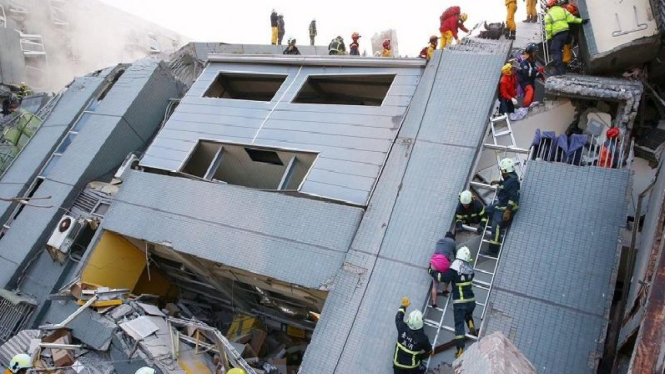 Petugas berusaha selamatkan warga yang tertimpa bangunan apartemen di gempa Taiwan.