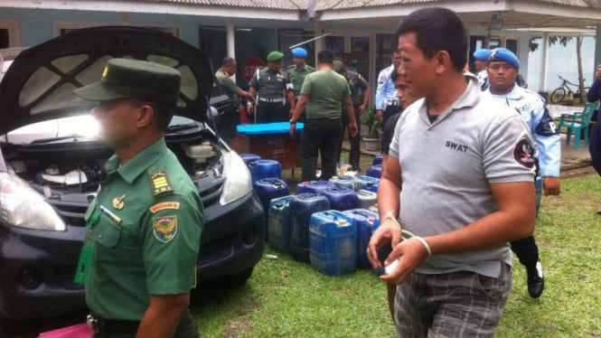 Seorang prajurit TNI Angkatan Darat (kanan) ditangkap saat berupaya menyelundupkan 1,4 ton minyak ilegal asal Kabupaten Musi Banyuasin, Sumatera Selatan, pada Kamis, 11 Februari 2016.