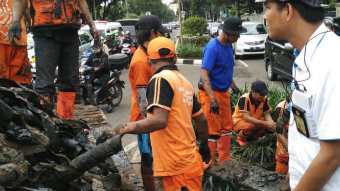 Petugas membersihkan sampah kabel di Jalan Medan Merdeka, Jakarta.