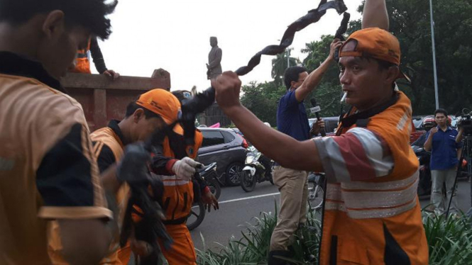 Petugas membersihkan sampah kabel di Jalan Medan Merdeka, Jakarta