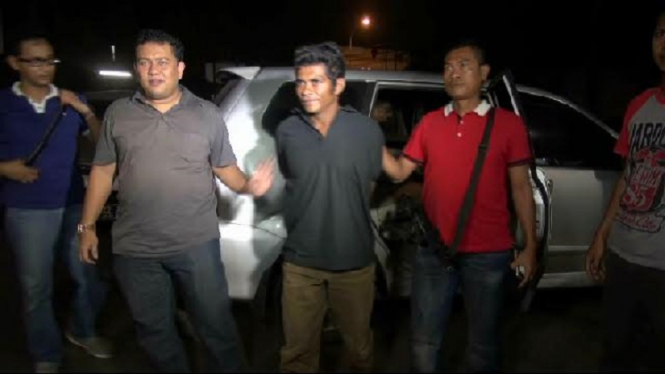 Pelaku pembunuh wanita di Cakung (tengah) saat dibawa ke kantor polisi.