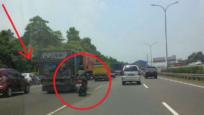 Ilustrasi: Pemotor di Tol Jagorawi yang lewati mobil polisi.