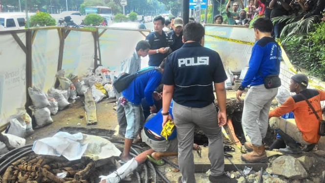 Polisi dan petugas Dinas Tata Air menguras air dalam got Istana.