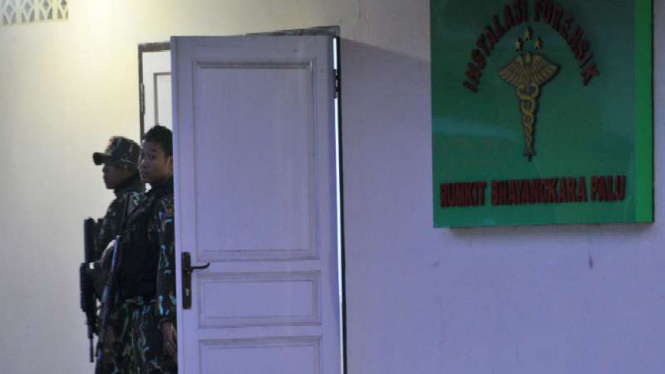 Dua anggota Brimob berjaga di depan pintu masuk ruang instalasi forensik tempat terduga teroris diperiksa di Rumah sakit Bhayangkara, Palu, Sulawesi Tengah