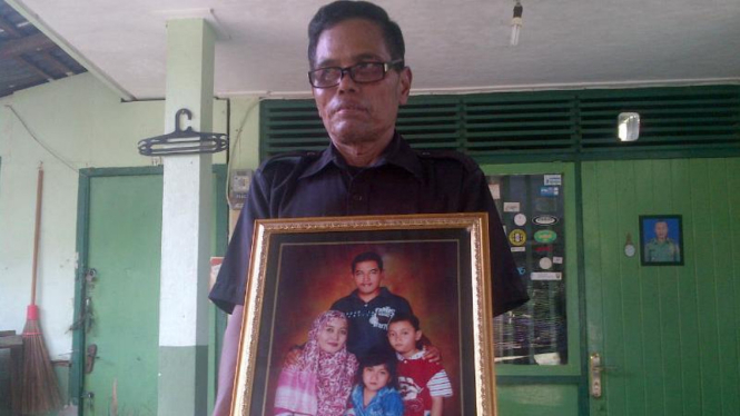Ponimin menunjukkan foto keluarga Kapten (Pnb) Agung Kurniawan, pilot helikopter TNI yang jatuh di Poso, Sulawesi Tengah, pada Minggu, 20 Maret 2016.