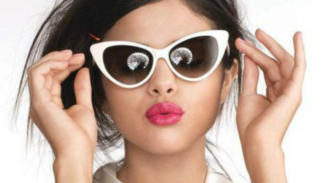 Selena Gomez menggunakan kacamata