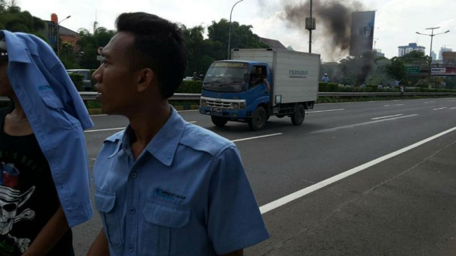 Sopir taksi membakar ban bekas di jalan tol