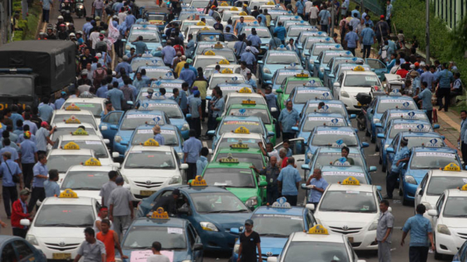 Ratusan supir taksi menggelar aksi demonstrasi menolak keberadaan angkutan umum online .