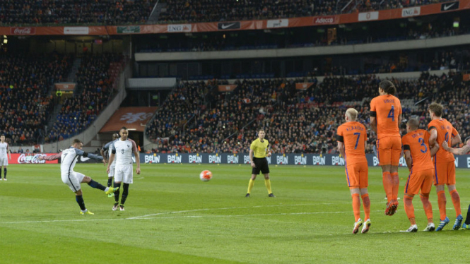 Striker Prancis, Antoine Griezmann, saat mengeksekusi sepakan bebas yang berbuah gol ke gawang Belanda.