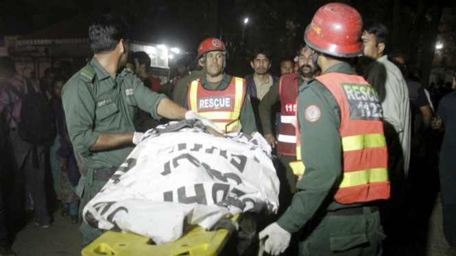 Petugas memindahkan tubuh korban dari lokasi ledakan di dekat sebuah taman di Lahore, Pakistan, 27 Maret 2016. 