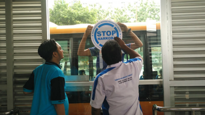 Pemasangan stiker antinarkoba di Halte Bus TransJakarta.