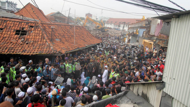 Petugas dan warga berkumpul saat pembongkaran di Kawasan Pasar Ikan Penjaringan, Jakarta, Senin (11/4/2016). 