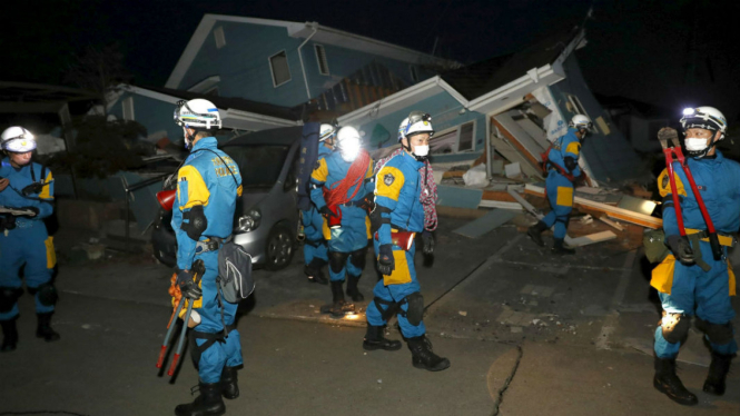 Polisi mengecek rumah yang runtuh akibat gempa di kota Mashiki, Kumamoto, selatan Jepang, 16 April 2016.