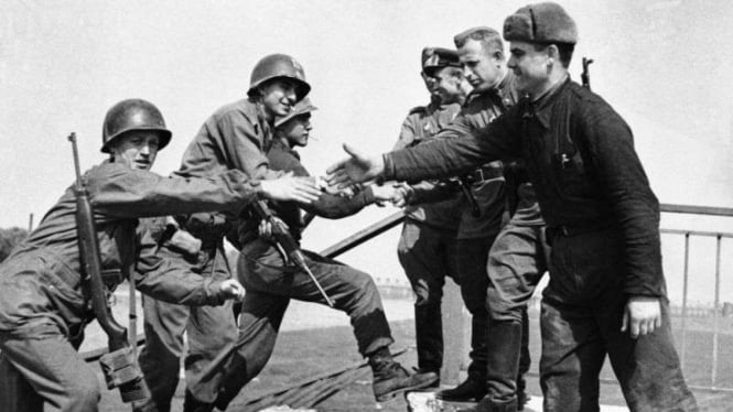 Pasukan AS (kiri) berjabat tangan dengan Pasukan Soviet usai memasuki Berlin