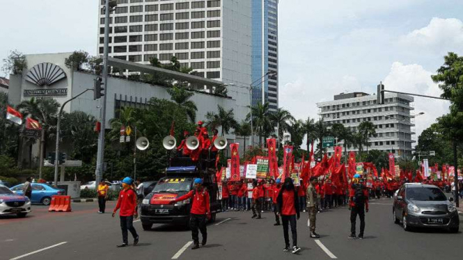 Massa buruh melintasi kawasan Bundaran Hotel Indonesia.