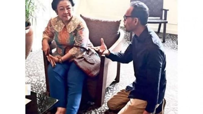 Foto Ketua Umum PDIP, Megawati Soekarnoputri (duduk di kursi), bersama seorang pria yang duduk bersimpuh.