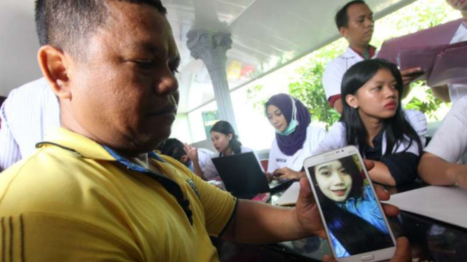  Seorang kerabat keluarga korban banjir bandang memperlihatkan foto keponakannya Eka Ramadani Nurul (21) saat melakukan proses ante mortem di RS Bhayangkara Polda Sumut, Medan, Senin (16/5/2016).