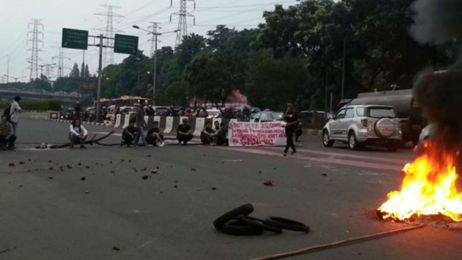 Mahasiswa gelar unjuk rasa dengan blokir jalan di kawasan UKI, Jakarta Timur, Jumat (20/5/2016).