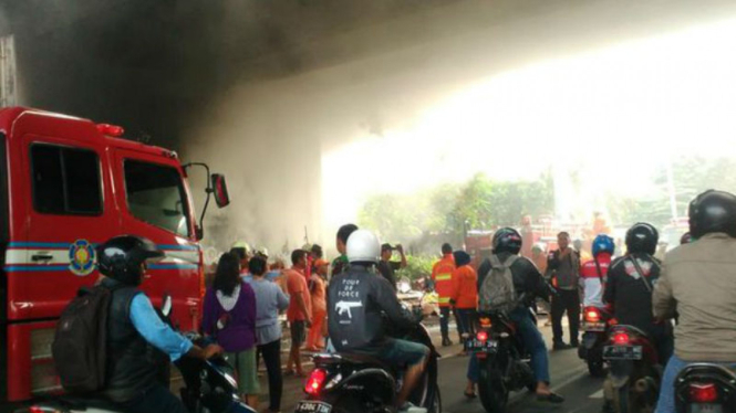 Petugas kebakaran tengah memadamkan api di kolong flyover Permata Hijau.