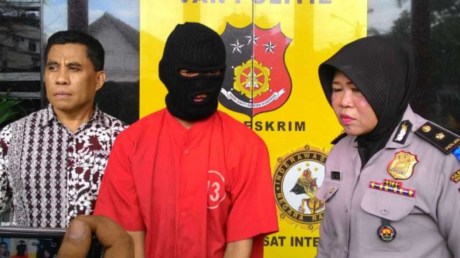 Didi alias Odin (tengah), tersangka pemerkosa bocah TK, saat diperlihatkan petugas Polrestabes Surabaya pada Jumat, 27 Mei 2016.
