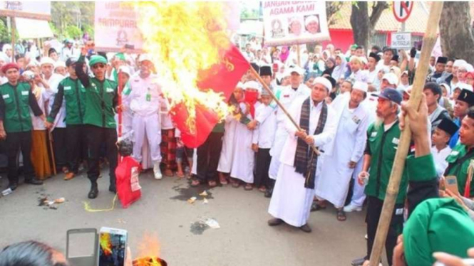 Sejumlah anggota FPI-Front Pembela Islam- menggelar aksi pembakaran bendera bergambar palu dan arit di Kabupaten Purwakarta, Minggu (29/5/2016)