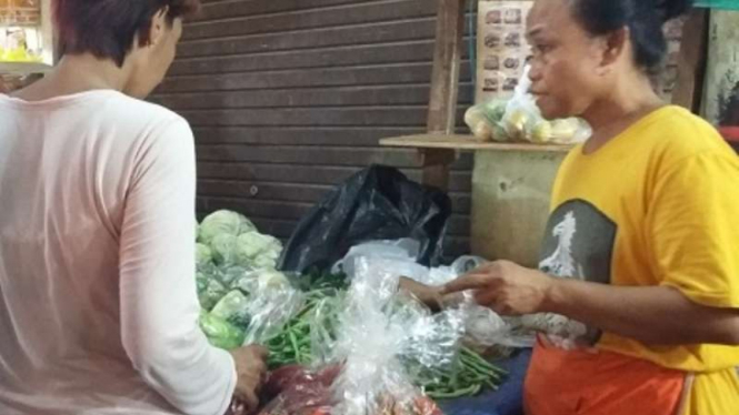 Suparmi, pedagang sayur sedang menjual dangannya ke pembeli