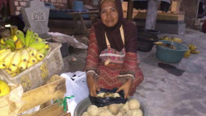 Romlah, seorang pedagang buah kinco yang diburu tiap Ramadan, di tempat pemakaman umum di Kabupaten Gresik, Jawa Timur.