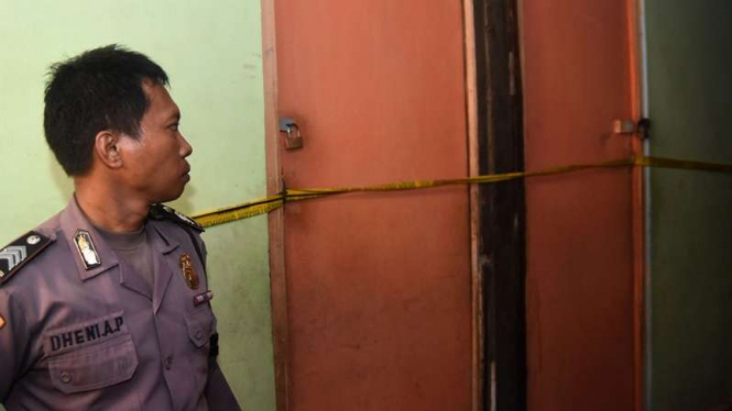 Seorang polisi berjaga di lokasi penangkapan terduga teroris di Surabaya
