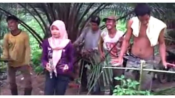 Aksi kocak band buruh sawit Indonesia menyanyikan lagu dangdut saat waktu istirahat. Seluruh pemain menggunakan pelepah sawit sebagai alat musik.