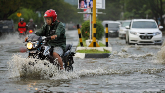 Seorang pengendara sepeda motor melewati banjir, di Kendari, Sulawesi Tenggara, Jumat (10/6/2016).