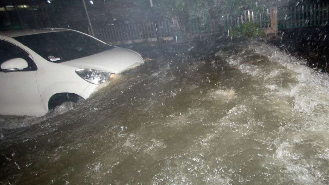 Sebuah mobil berusaha melewati banjir di jalan Kampung Nias, Padang
