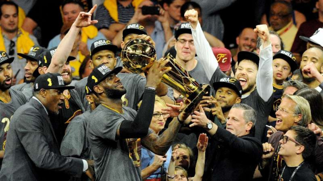 Forward Cleveland Cavaliers, LeBron James, saat mengangkat trofi NBA.